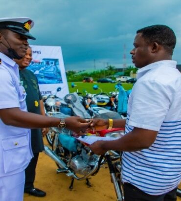 Engr. Emmanuel Inyang, Director of Petroleum and Lt. Commander Samuel Olowookere representing the Commanding officer, FOB Ibaka, presenting to one of the beneficiaries of Mbo community.